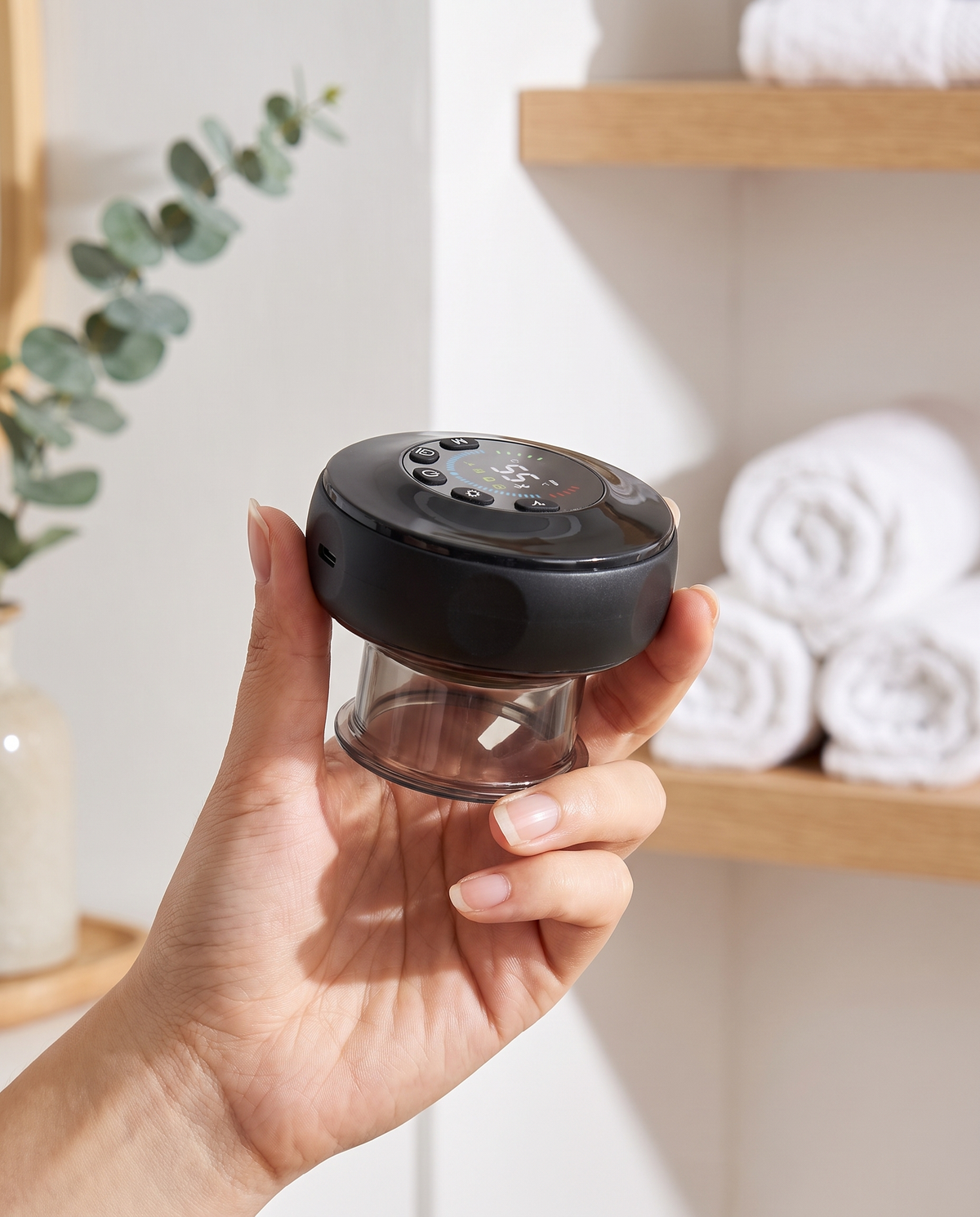 Hand holding the Himra smart cupping massager