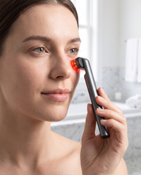 Woman using the Himra warm eye wand under her eye