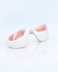 Himra red light eye massager with its light on, on a light blue background
